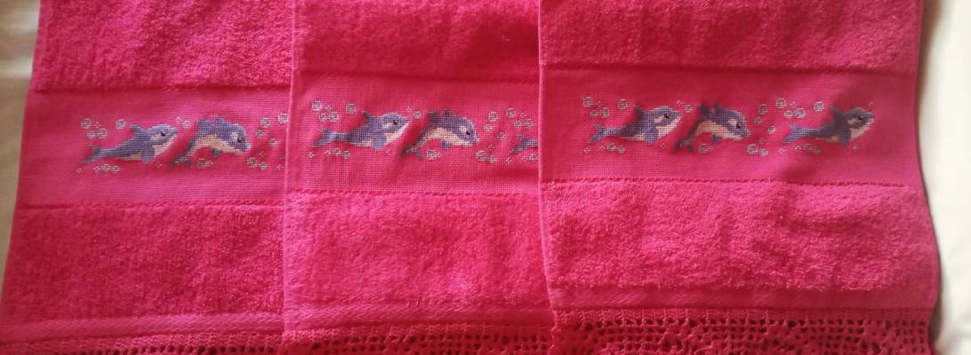 Toallas bordadas a punto de cruz con delfines y puntilla a ganchillo